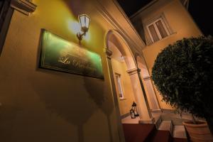 a sign on the side of a building with a plant at Hotel La Residenza - Adults only in Timişoara