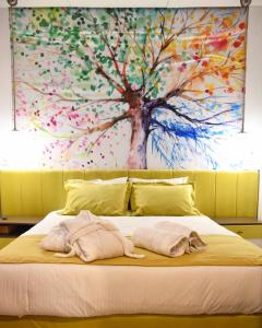 a large painting of a tree on a bed at Lycabettus Exclusive Apartments in Athens