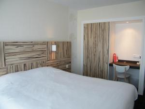 a hotel room with a bed and a desk at Hôtel Le Nautic in Arcachon