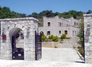 an entrance to a stone building with a gate at Lalloudes Seaside Accommodation in Éxo Nímfion
