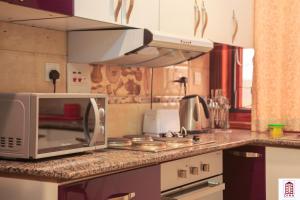 a microwave oven sitting on a counter in a kitchen at Dina Apartments in Kampala +20 photos
