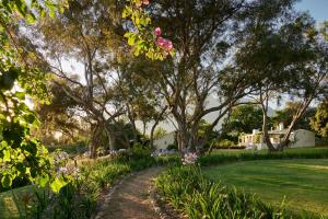 a garden with pink flowers and trees at Boschendal Farm Estate in Franschhoek