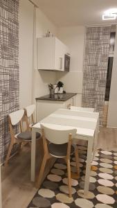 eine Küche mit einem weißen Tisch, 2 Stühlen und einem Tisch in der Unterkunft Ferienwohnung Villa Josephine in Badenweiler