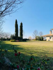 a field of green grass with a house and trees at B&B Beauty House in Cesena