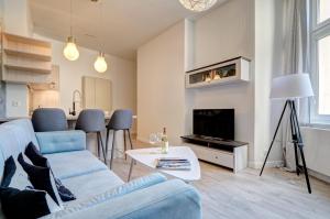 ソポトにあるDom & House Apartment Monte Cassino 21のリビングルーム(青いソファ、テレビ付)