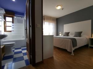 a bedroom with a bed and a bathroom with a tub at Hotel El Trasgu in Cangas de Onís