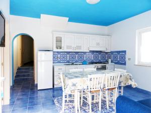 Cavadozza في بونسا: مطبخ ازرق وابيض مع طاولة وكراسي