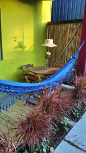 a hammock in a patio with a table and plants at Cantinho Maresias in Maresias