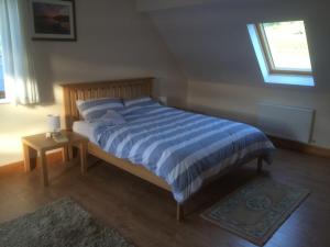 ein Bett mit einer blau-weißen gestreiften Bettdecke in einem Schlafzimmer in der Unterkunft Achill Alantic Dream in Derreen