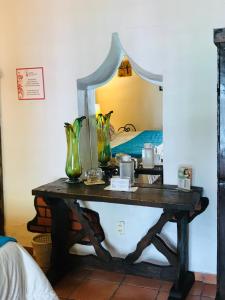una mesa con dos jarrones en ella con un espejo en Hotel Casa Armonia, en Guadalajara