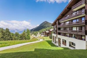 Blick auf die Seite eines Gebäudes mit einer Straße in der Unterkunft Résidence Pierre & Vacances Le Quartz in Belle Plagne
