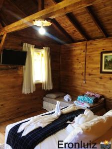 烏魯比西的住宿－Cabanas Fazenda da Raia，一间带两张床铺的卧室,位于带木墙的房间内