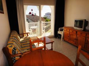 - un salon avec un canapé, une table et une télévision dans l'établissement Bertur Al-Andalus, à Alcossebre