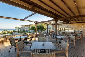 un patio esterno con tavoli, sedie e vista sull'oceano di Solimar Aquamarine Resort a Gerani Chanion