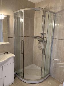 a shower with a glass door in a bathroom at Les Victorines - Proche Aéroport in Nice