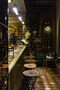 un restaurant avec une rangée de tabourets et un bar dans l'établissement G-Rough, Rome, a Member of Design Hotels, à Rome