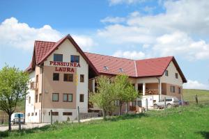 a large building with a red roof at Pension Laura Cheile Turzii in Petreştii de Jos