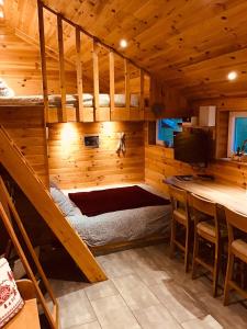 a room with a bunk bed and a bar in a cabin at le chalet de la ferme du tertre in Villers-au-Tertre