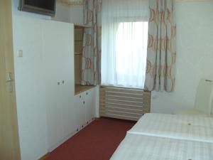 Kleines Zimmer mit einem Bett, einem Fenster und einem Fenster in der Unterkunft Frühstückspension Leopold Janu in Senftenberg