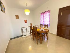 een eetkamer met een houten tafel en stoelen bij Le Royce Private Villa in Pondicherry