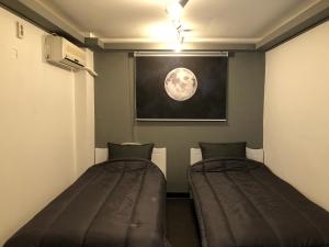 2 posti letto in una camera con una foto della luna di Apollo Guesthouse a Seul