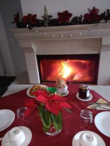 a christmas table with a fireplace and a red table cloth at B&B Tufaro Alberico in Terranova di Pollino