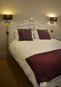 a bedroom with a large white bed with two pillows at The Bell in Shifnal
