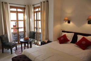 1 dormitorio con cama, mesa y ventana en Riad Spa Dar Nimbus, en Marrakech