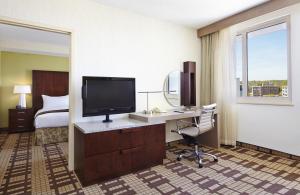 a hotel room with a desk with a television and a bed at Hotel Silver Spring in Silver Spring