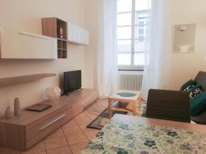 un soggiorno con divano e TV di MistrangeloHome 3 - Appartamento in Pieno Centro a Savona