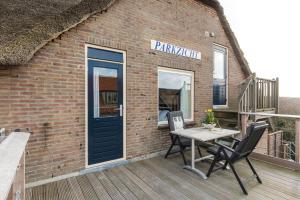 een bakstenen gebouw met een tafel en stoelen op een terras bij Appartementen Parkzicht in Bergen aan Zee