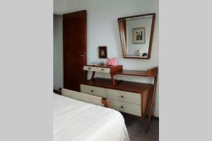 una camera da letto con un letto, un lavandino e uno specchio di Confortable 2 ambientes, excelente ubicación a Miramar