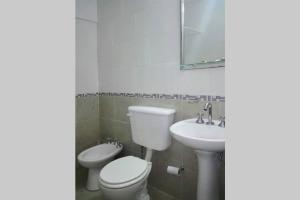 un baño con inodoro y lavabo en Confortable 2 ambientes, excelente ubicación, en Miramar 19 fotos más