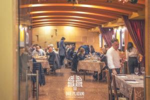 grupa ludzi siedzących przy stolikach w restauracji w obiekcie Hotel Due Platani w mieście Cornedo Vicentino