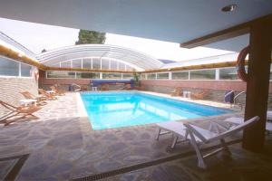 a pool with chairs and a table and a swimming pool at Hotel La Vega in Alcalá de la Selva