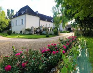 ein Haus mit rosa Blumen vor einer Einfahrt in der Unterkunft Domaine Pont Juillet in Fontaines