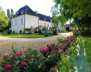 una casa con flores rosas frente a una entrada en Domaine Pont Juillet, en Fontaines