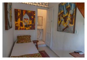 una habitación con una cama y algunas pinturas en la pared en Pousada Cravo e Canela, en Arraial d'Ajuda
