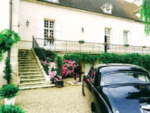 un coche aparcado delante de una casa con flores en Domaine Pont Juillet, en Fontaines