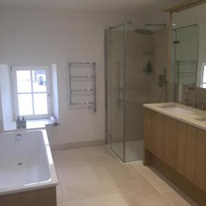 La salle de bains est pourvue d'une douche en verre et d'un lavabo. dans l'établissement Farmhouse in a working winery with vineyard views, à Marigny-Brizay