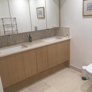 La salle de bains est pourvue de 2 lavabos et de toilettes. dans l'établissement Farmhouse in a working winery with vineyard views, à Marigny-Brizay