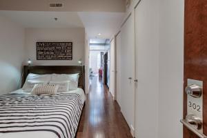 a bedroom with a bed with a black and white striped blanket at Les Immeubles Charlevoix - Le 1174 in Quebec City