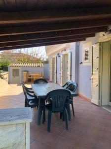 una mesa de madera y sillas en un patio en Villetta di Giusy, en Marina di Modica