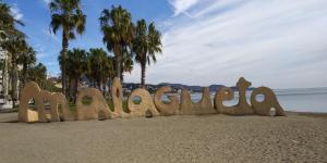 a sand sculpture of the word paradise on a beach at Fantásticos Lofts Malagueta in Málaga