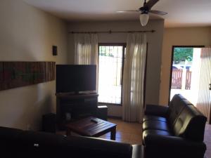 sala de estar con sofá y TV de pantalla plana en Casa familiar en Arraial do Cabo