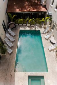 an overhead view of a large swimming pool with chairs at Cento Collins Stays by Mercury South Beach in Miami Beach