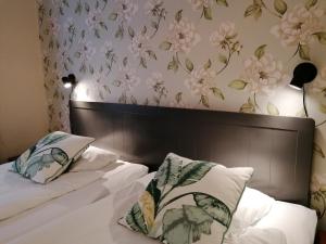 a bedroom with a bed with flowers on the wall at Hotel Park Allé in Kristianstad