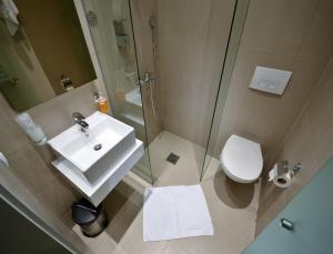 a bathroom with a shower and a sink and a toilet at Garni Hotel Krevet&Dorucak in Niš