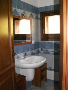 a bathroom with a white sink and two windows at VILLETTA SUL MARE, PANORAMICA in Villaputzu