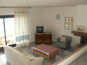 a living room with a couch and a tv at VILLETTA SUL MARE, PANORAMICA in Villaputzu